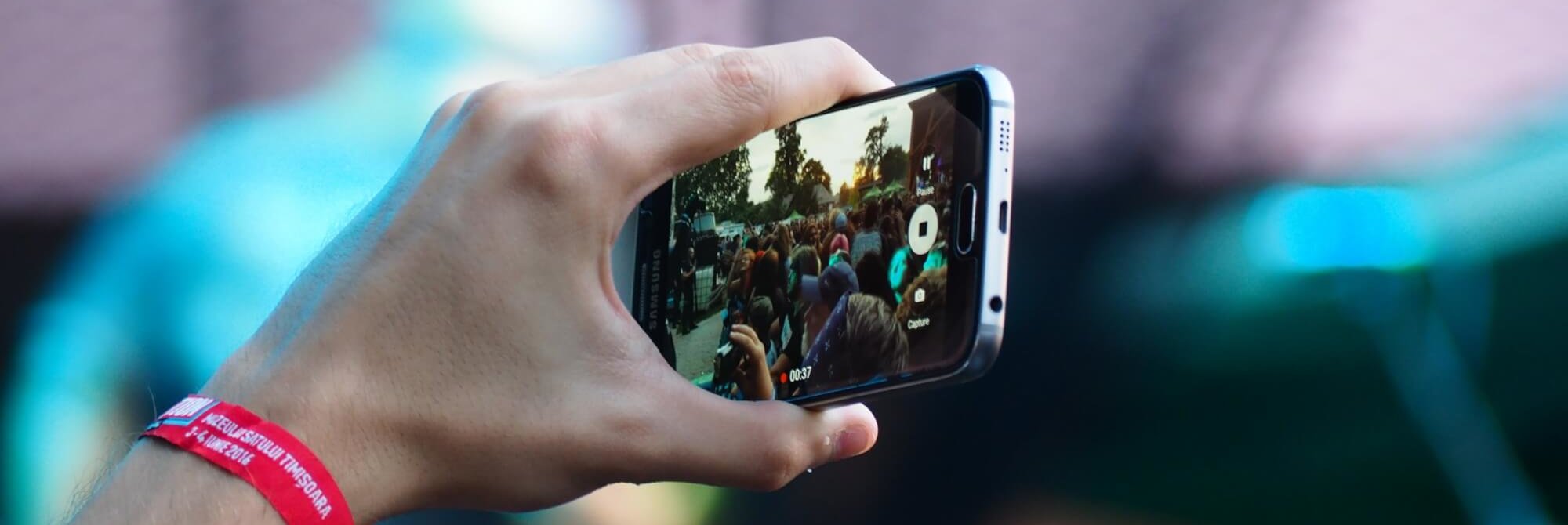 Eine Person filmt auf einem Festival. Diese Mobile-Reporting-Apps brauchst du auf deinem Handy.